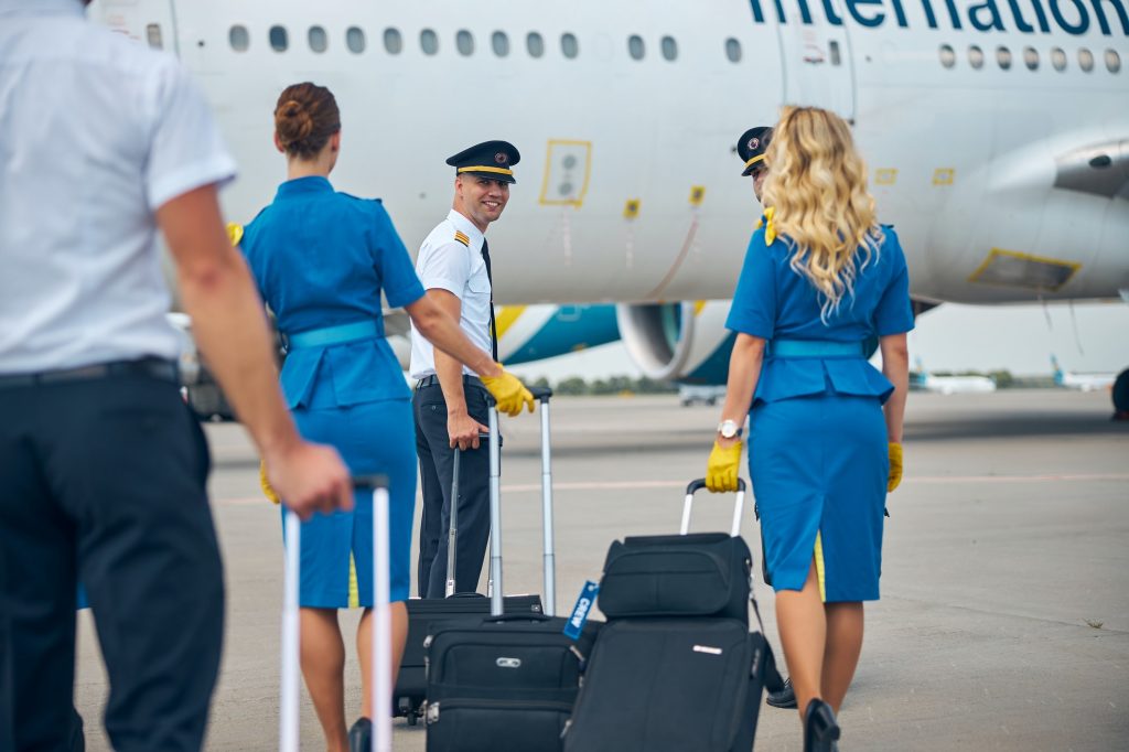 pilots-and-stewardesses-carrying-travel-bags-at-airport.jpg